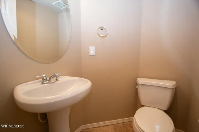 a bathroom with a toilet a sink and a mirror