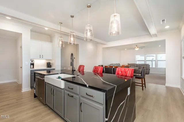 a kitchen with a stove a refrigerator and a dining table with wooden floor