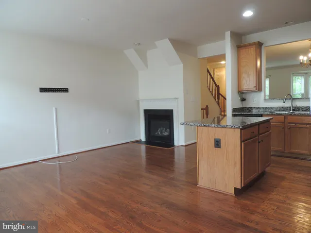 a kitchen with granite countertop a sink cabinets and wooden floor