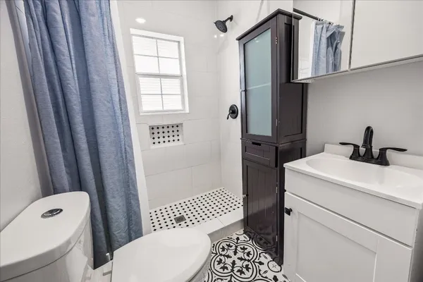 a bathroom with a sink a toilet and shower
