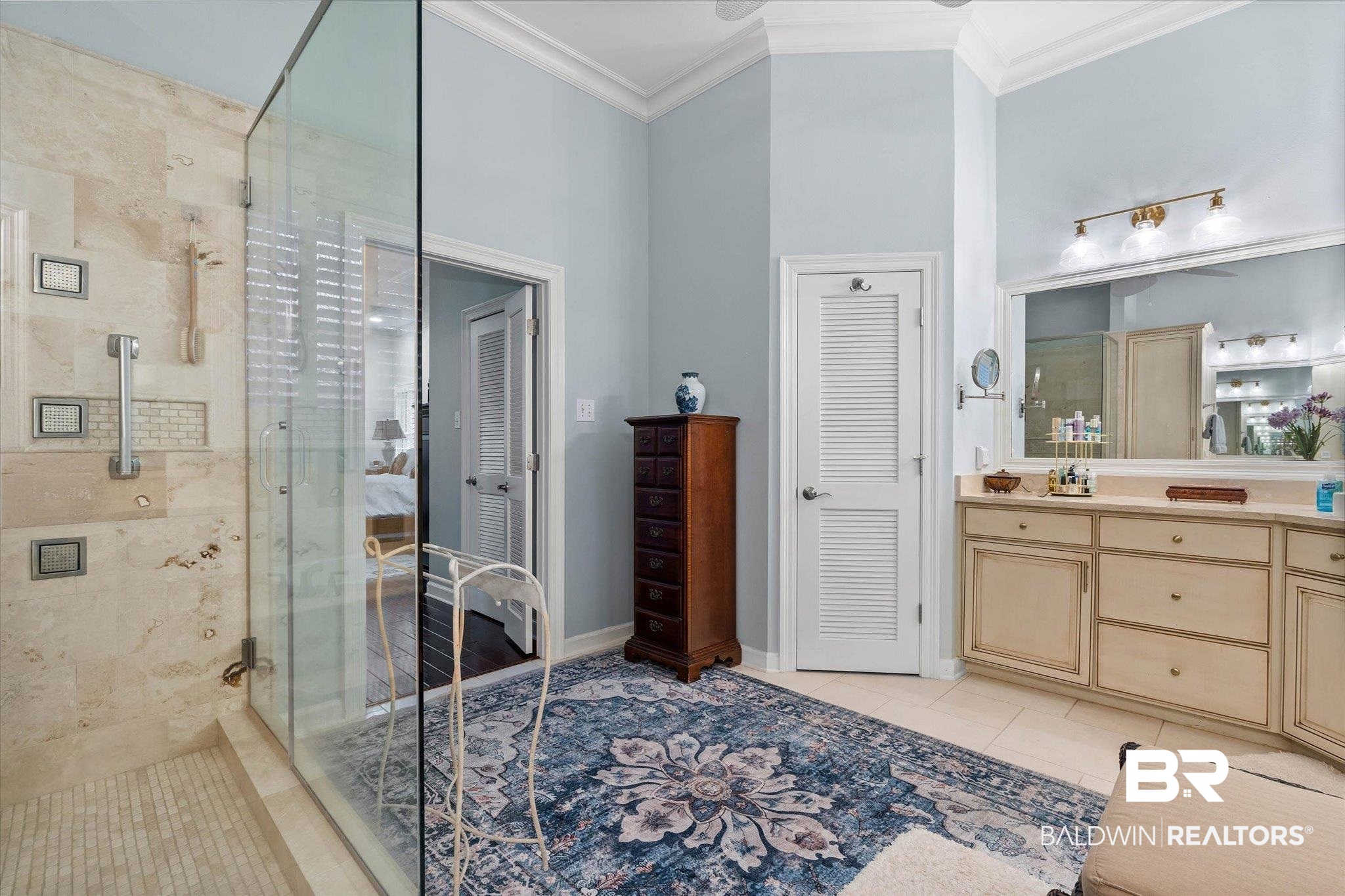 136 Old Mill Road Fairhope, AL 36532 - Photo 18 of 36 Spacious bathroom featuring a glass-enclosed shower with stone tile, a double vanity with ample storage, a large mirror, and vaulted ceilings