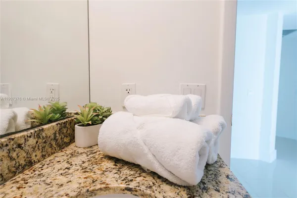 a living room with a bed and a potted plant