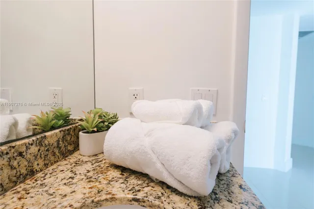 a living room with a bed and a potted plant