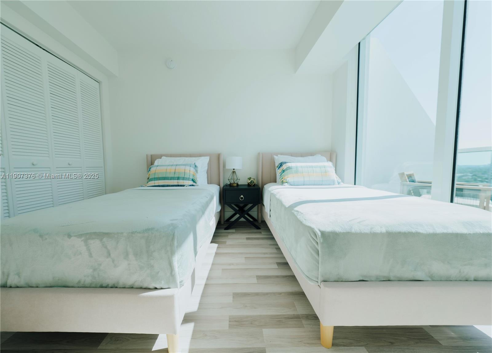 41 Southeast 5th Street, Unit 1217 Miami, FL 33131 - Photo 15 of 24 a bedroom with a bed and wooden floor