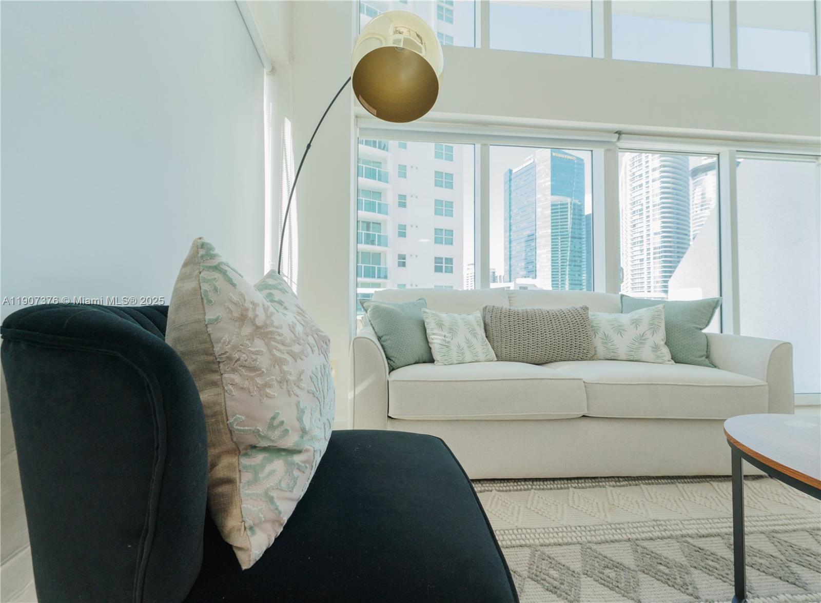 41 Southeast 5th Street, Unit 1217 Miami, FL 33131 - Photo 6 of 24 a living room with furniture and a floor to ceiling window