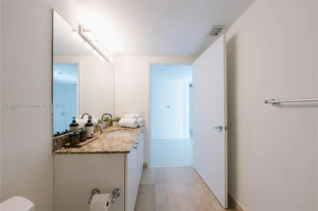 a bathroom with a granite countertop sink and a mirror