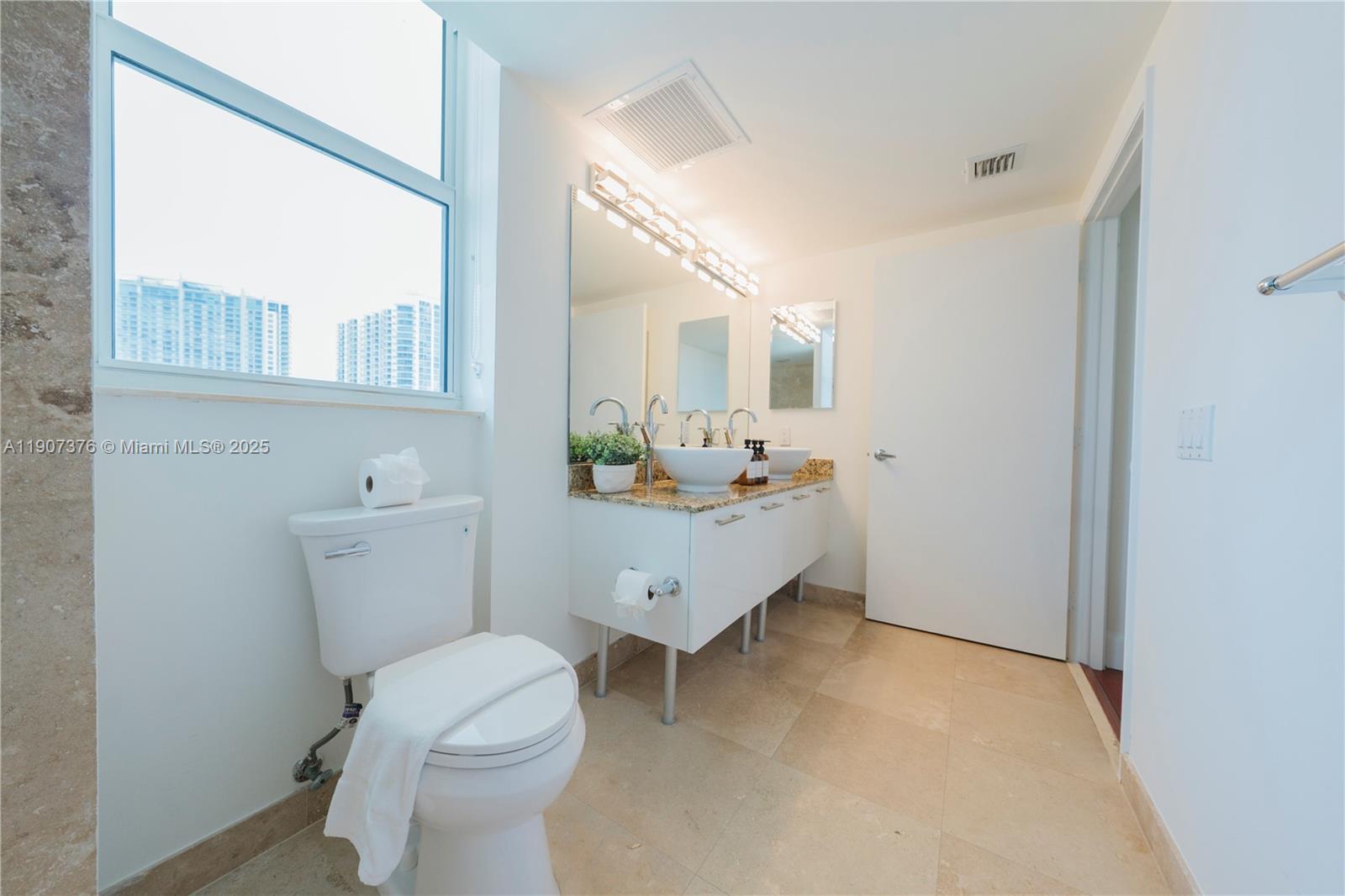41 Southeast 5th Street, Unit 1217 Miami, FL 33131 - Photo 10 of 24 a bathroom with a toilet sink and mirror