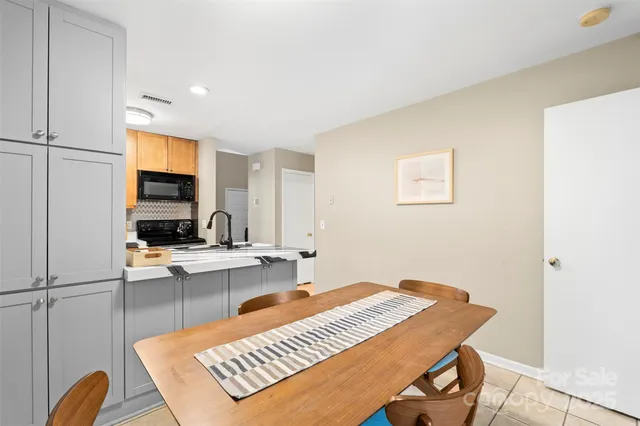 a view of a kitchen with kitchen island a sink stainless steel appliances and cabinets