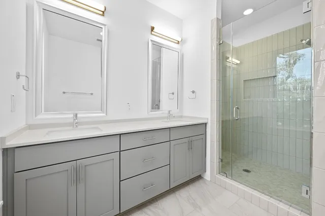 a bathroom with double sink and shower