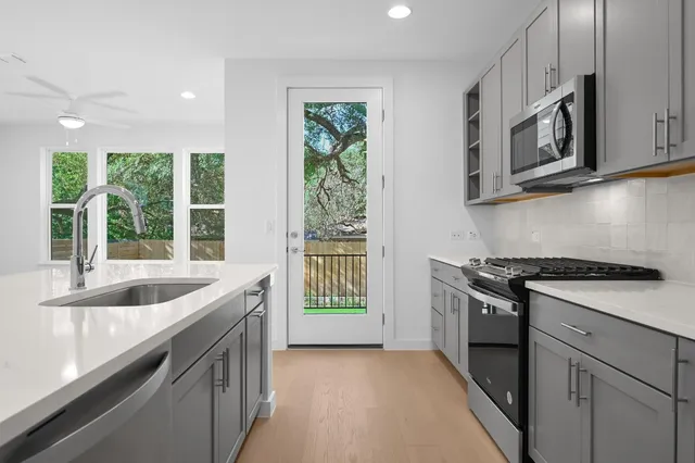 a kitchen with stainless steel appliances granite countertop a sink and a stove