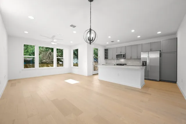 a view of a kitchen with stainless steel appliances granite countertop a large counter top and couches