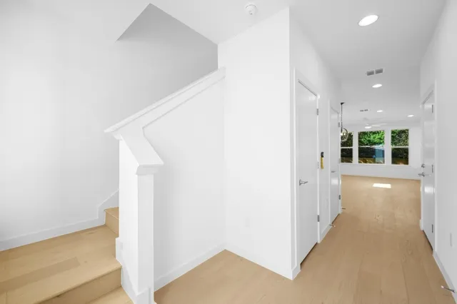 a view of a hallway with wooden floor and staircase