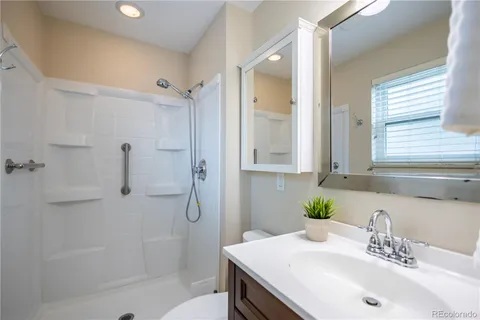 a bathroom with a sink shower and a mirror