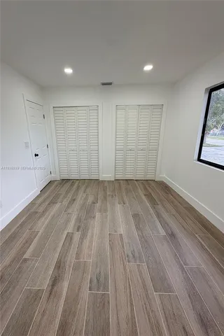 a view of a room with wooden floor and white walls