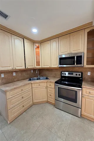 a kitchen with granite countertop white cabinets appliances and a sink