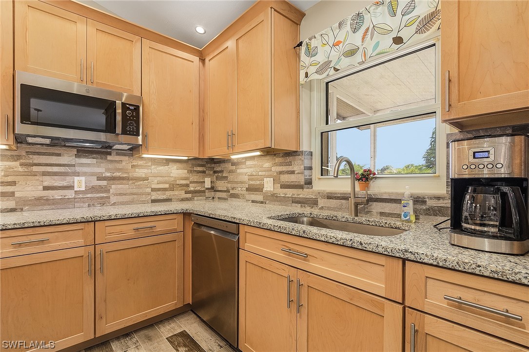 13673 Hampton Road Bokeelia, FL 33922 - Photo 11 of 28 a kitchen with stainless steel appliances granite countertop a sink stove and microwave