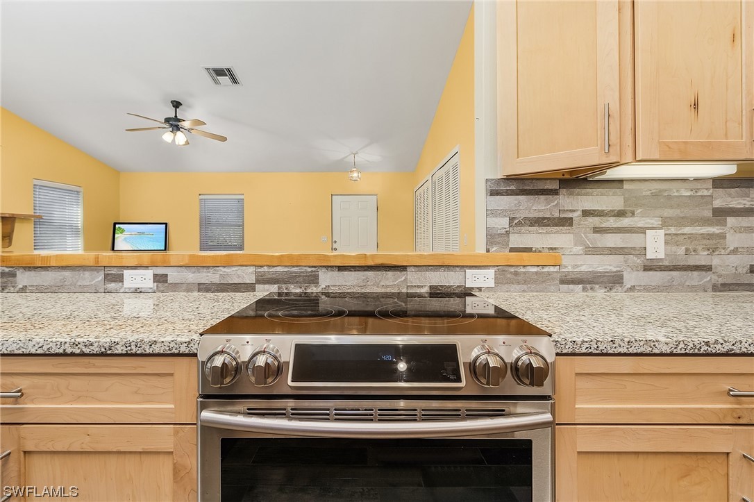13673 Hampton Road Bokeelia, FL 33922 - Photo 12 of 28 a kitchen with granite countertop a stove sink and cabinets