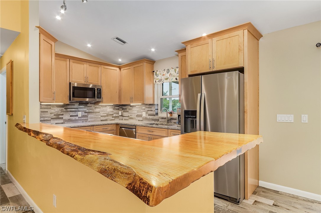 13673 Hampton Road Bokeelia, FL 33922 - Photo 14 of 28 a kitchen with stainless steel appliances granite countertop a refrigerator a stove and a sink