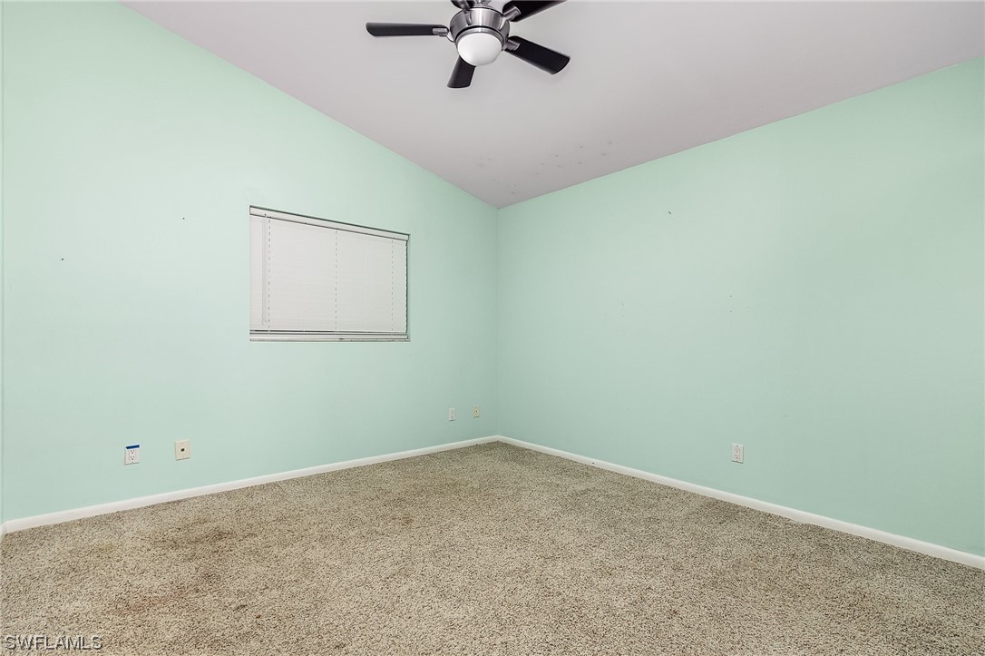13673 Hampton Road Bokeelia, FL 33922 - Photo 18 of 28 an empty room with a ceiling fan and window