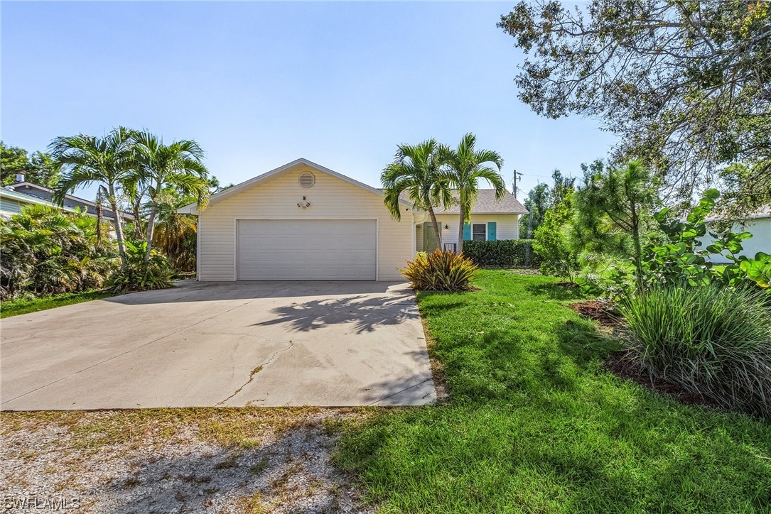 13673 Hampton Road Bokeelia, FL 33922 - Photo 2 of 28 a front view of a house with a yard and garage