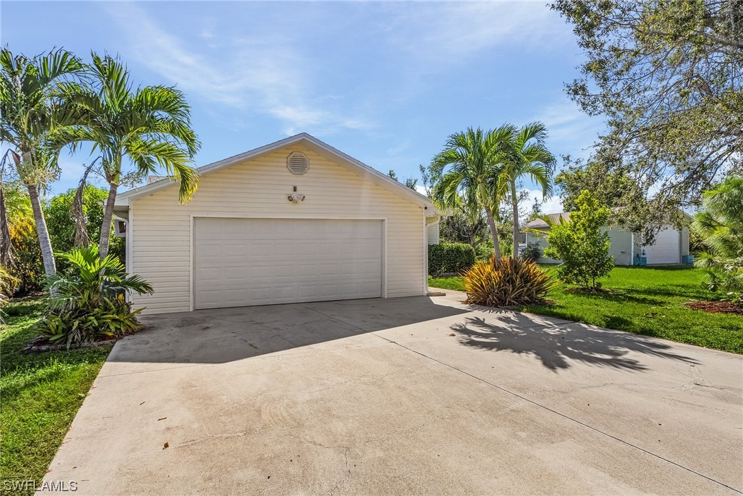 13673 Hampton Road Bokeelia, FL 33922 - Photo 4 of 28 a front view of a house with a yard and garage