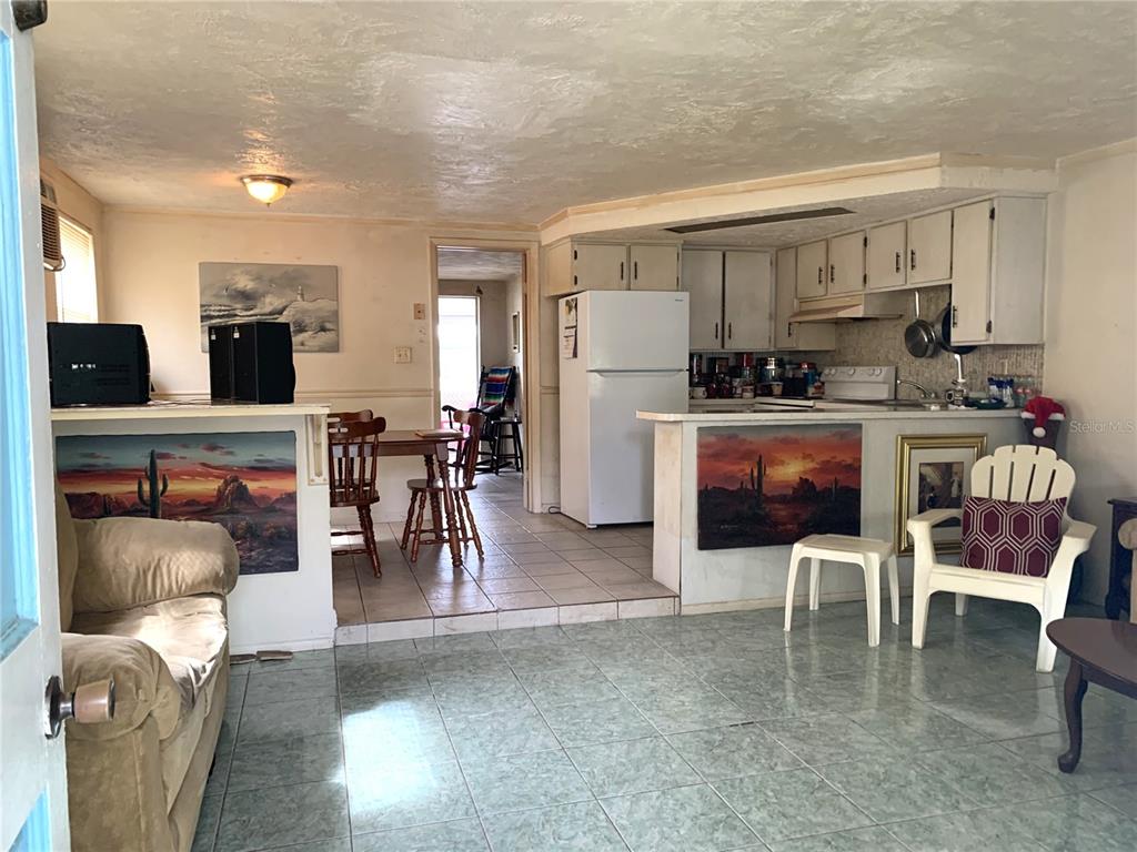 12629 1st Isle Hudson, FL 34667 - Photo 11 of 29 a living room with furniture and a dining table with kitchen view