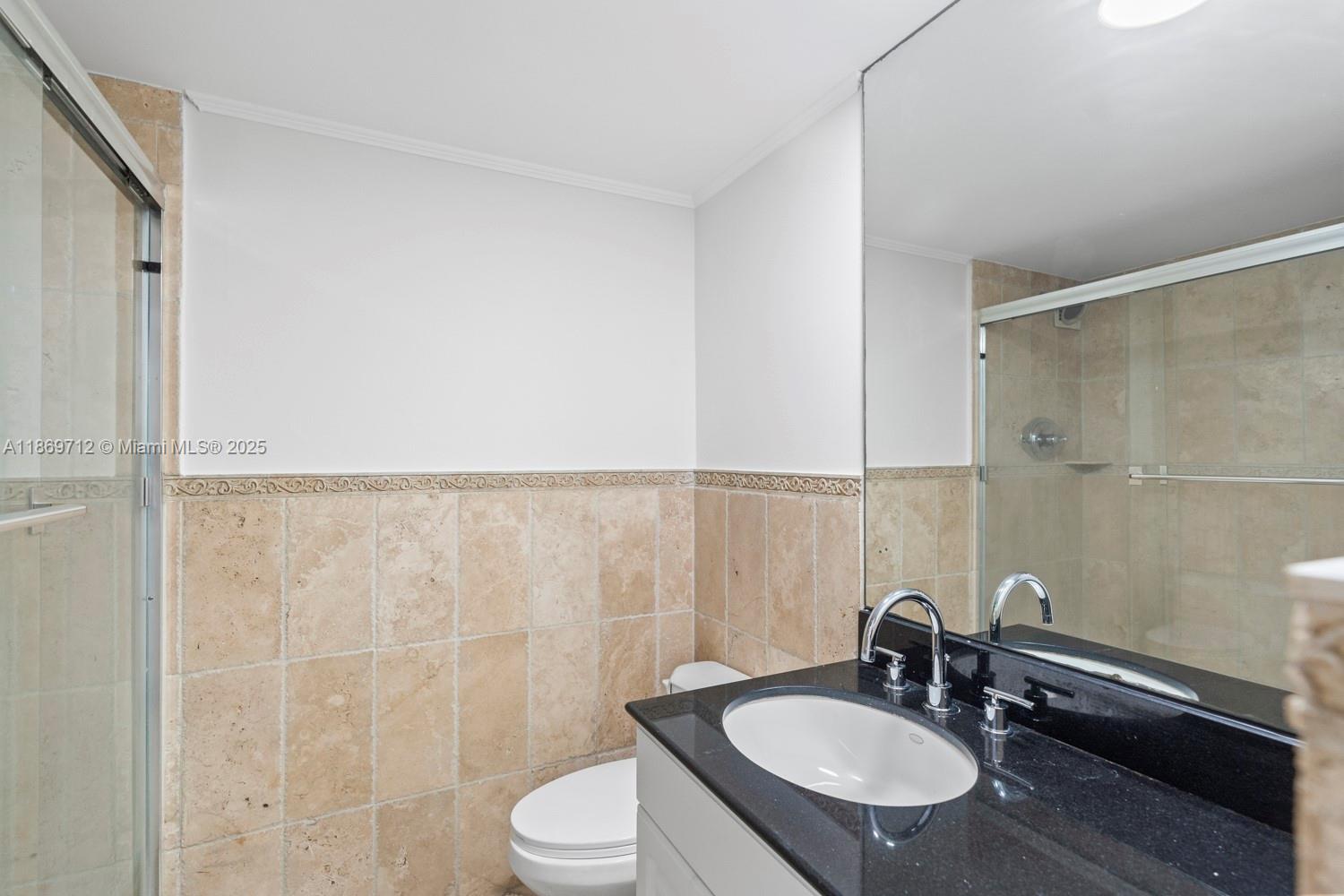 5161 Collins Avenue, Unit 701 Miami Beach, FL 33140 - Photo 15 of 47 a bathroom with a sink a toilet and a mirror