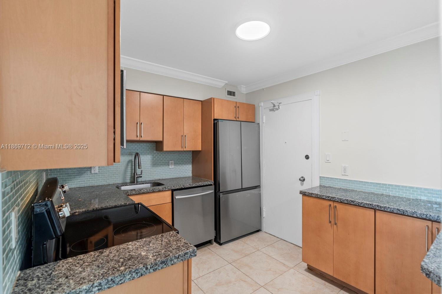 5161 Collins Avenue, Unit 701 Miami Beach, FL 33140 - Photo 10 of 47 a kitchen with stainless steel appliances granite countertop a refrigerator stove and sink