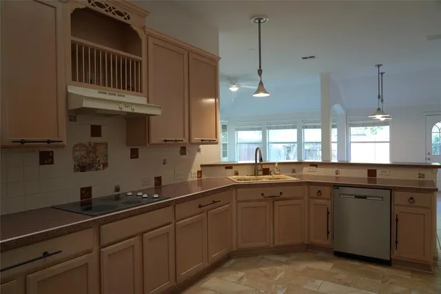 a large kitchen with a sink and stainless steel appliances