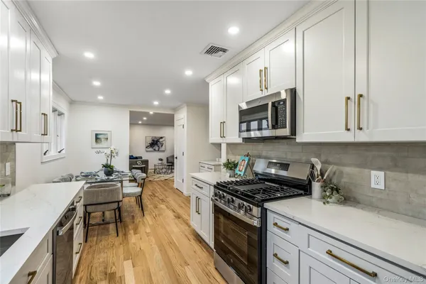 a kitchen with stainless steel appliances a stove a sink a microwave a refrigerator and cabinets