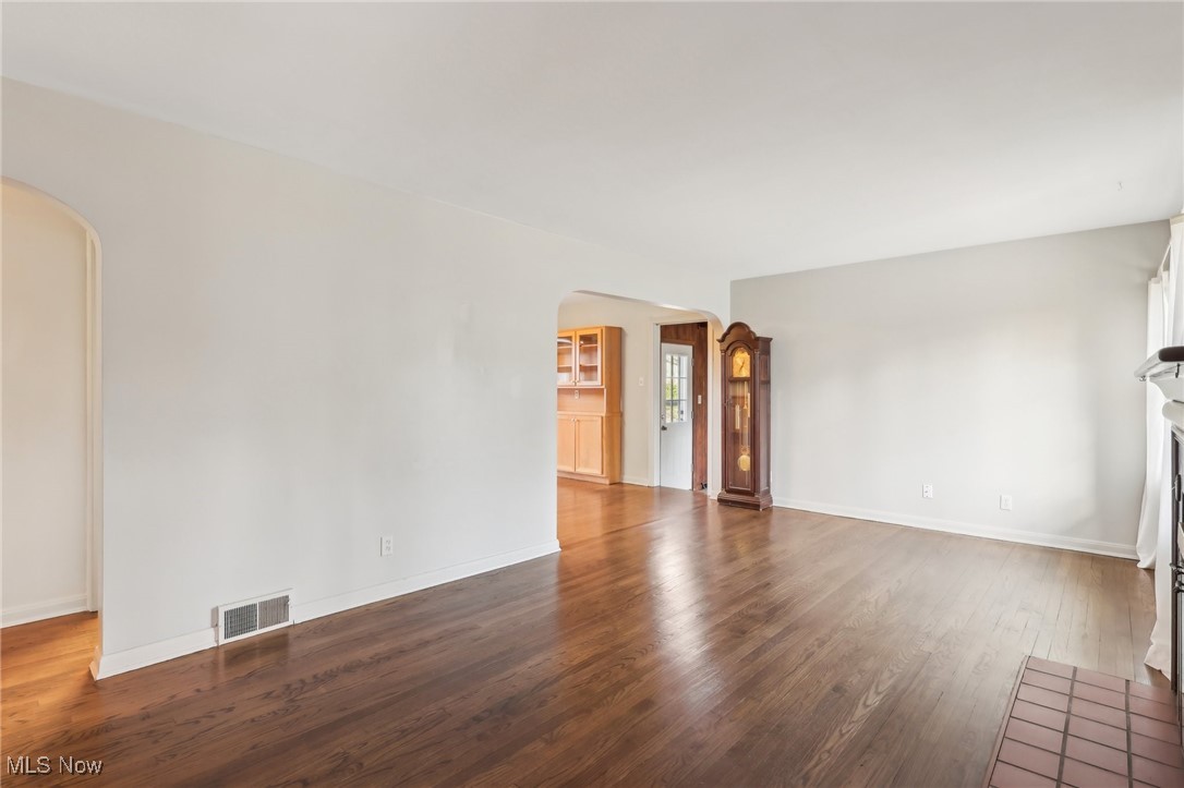 2045 Stabler Road Akron, OH 44313 - Photo 8 of 35 Unfurnished living room with arched walkways, wood finished floors, visible vents, and baseboards
