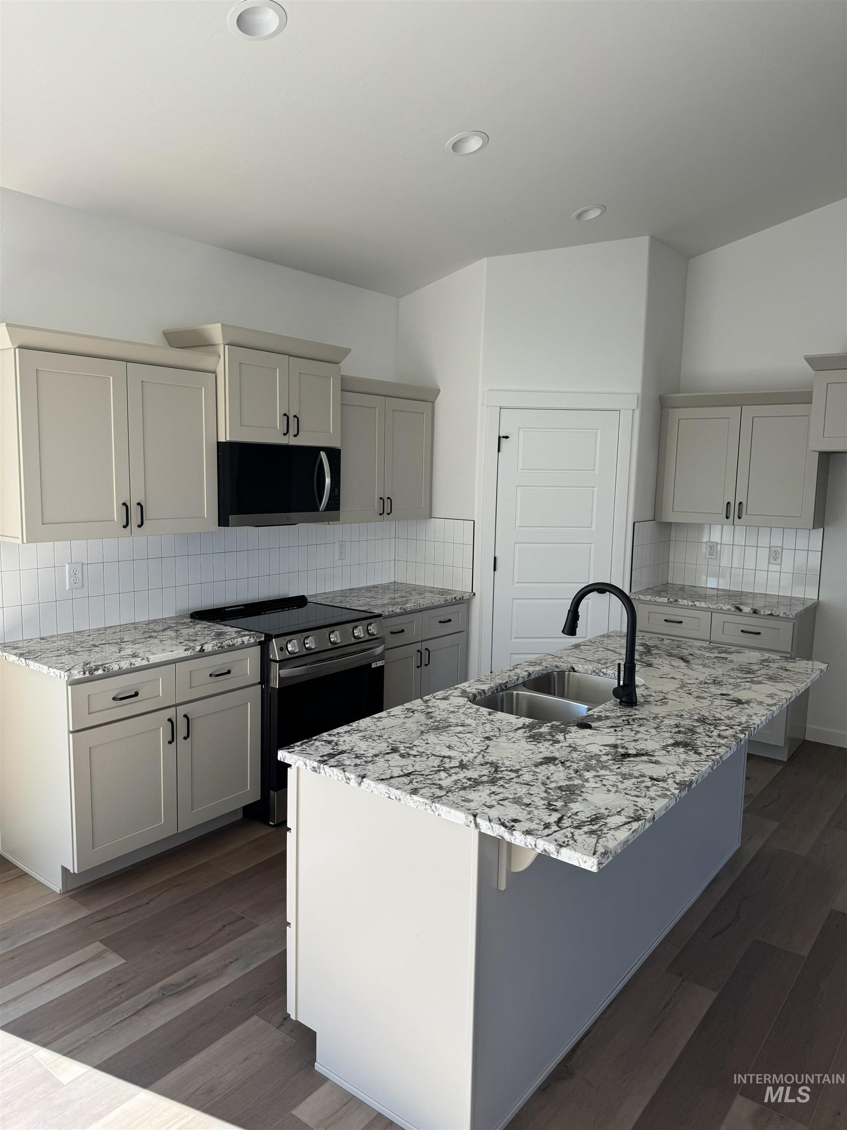 1295 Starlight Loop Twin Falls, ID 83301 - Photo 2 of 11 Kitchen with light stone counters, decorative backsplash, stainless steel range with electric stovetop, gray cabinetry, and recessed lighting