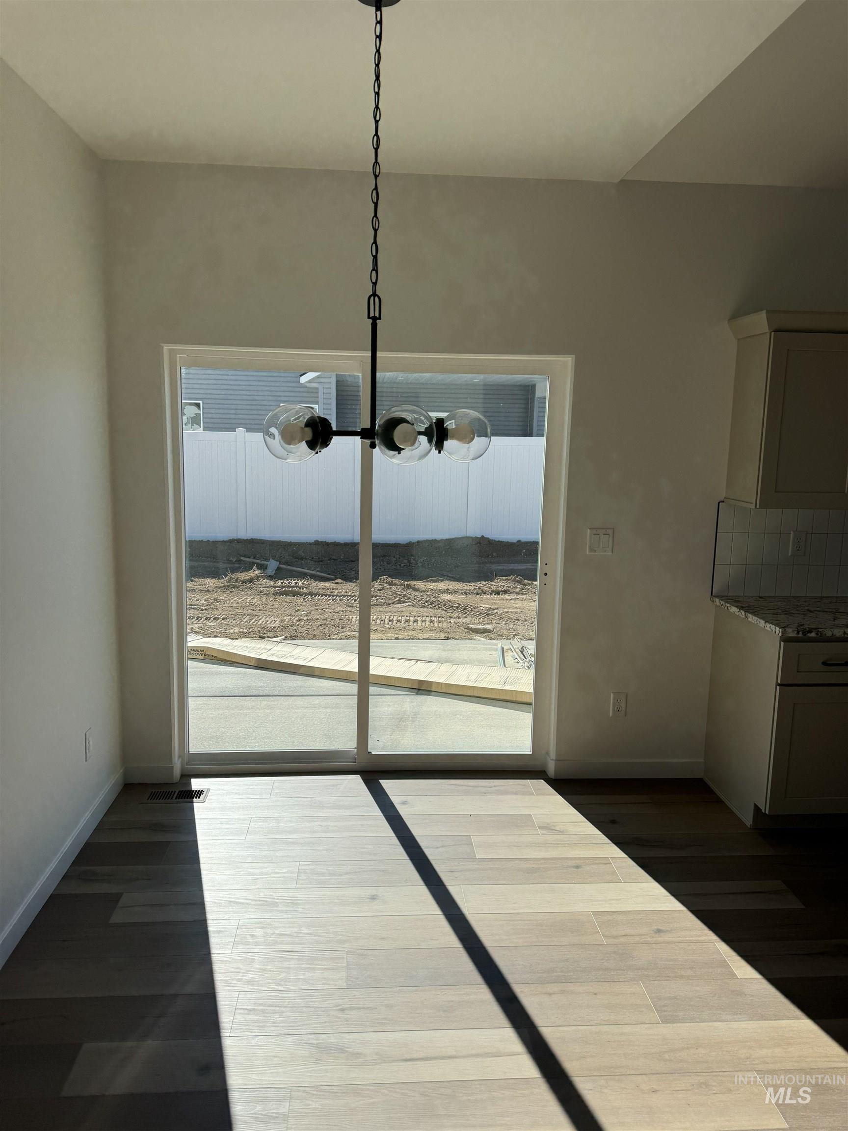 1295 Starlight Loop Twin Falls, ID 83301 - Photo 3 of 11 Unfurnished dining area with dark wood finished floors and a chandelier