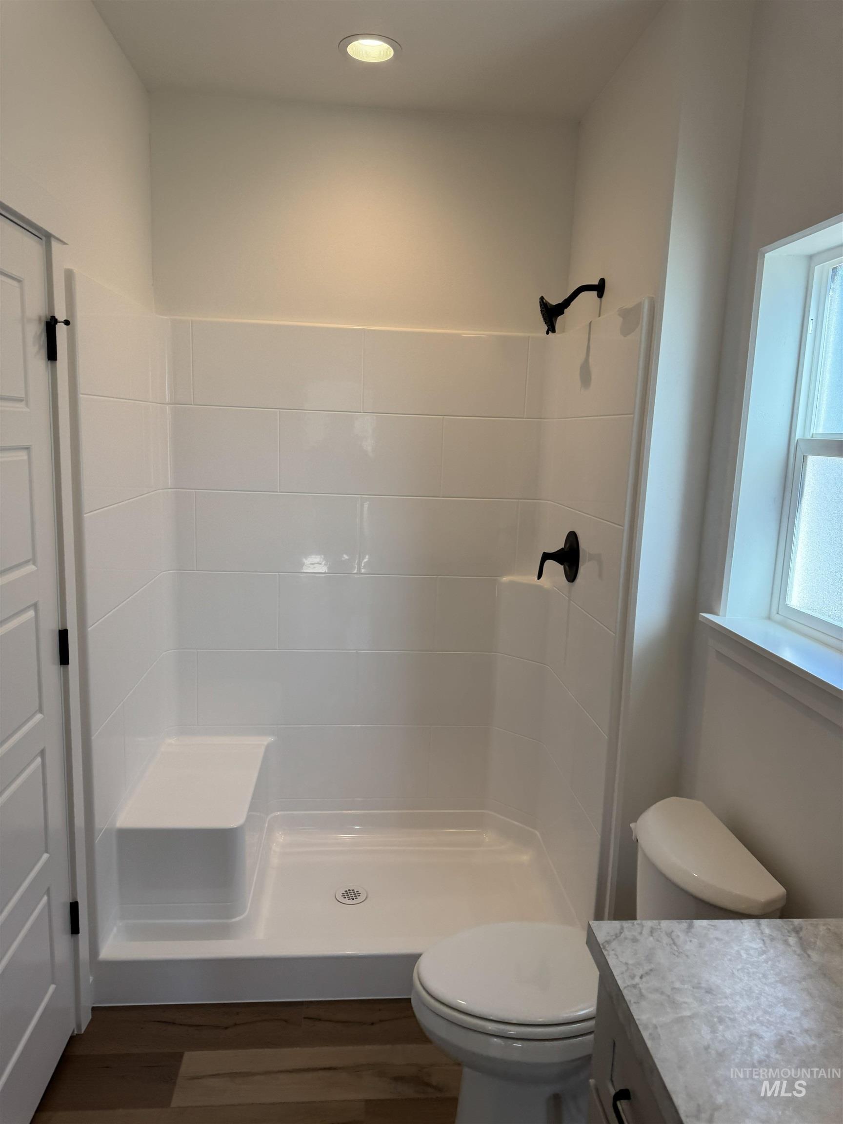 1295 Starlight Loop Twin Falls, ID 83301 - Photo 7 of 11 Full bathroom with a shower stall, vanity, and dark wood-style flooring