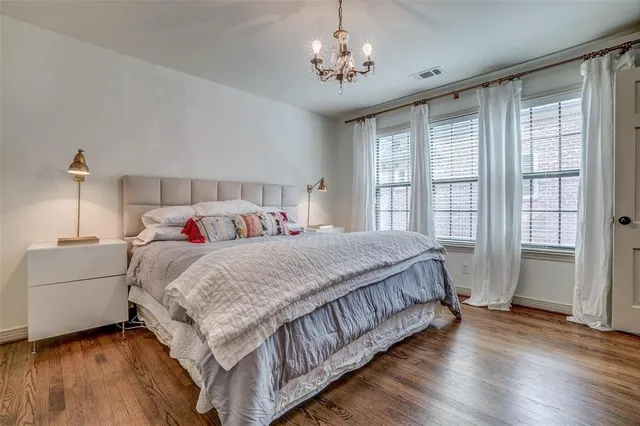 a bedroom with a large bed and a chandelier