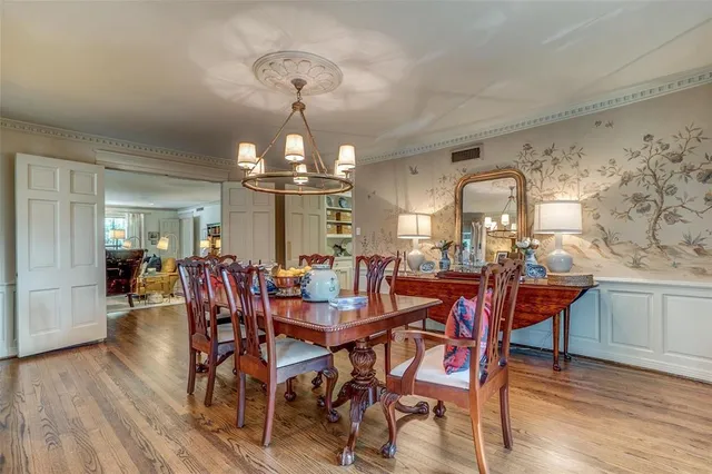 a view of a dining room with furniture a chandelier and wooden floor