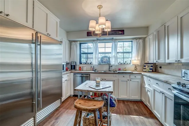 a kitchen with a center island appliances and cabinets