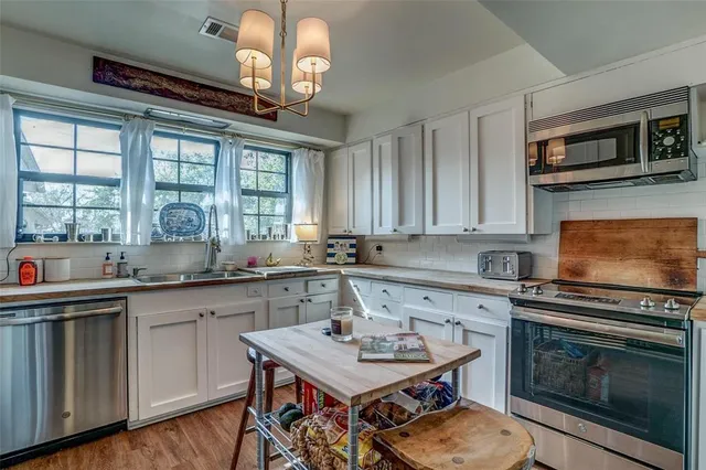 a kitchen with stainless steel appliances a stove sink microwave and cabinets