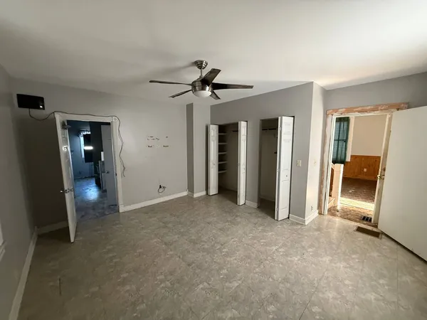 a view of empty room with furniture and a ceiling fan