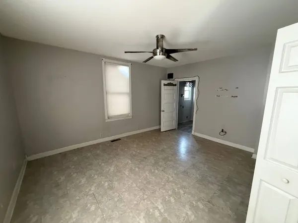 an empty room with windows and fan