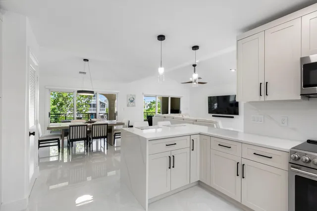 a kitchen with white cabinets and sink