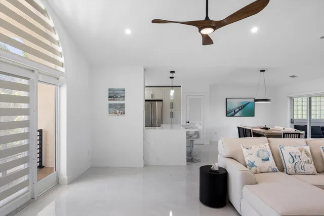 a living room with furniture a ceiling fan and a window