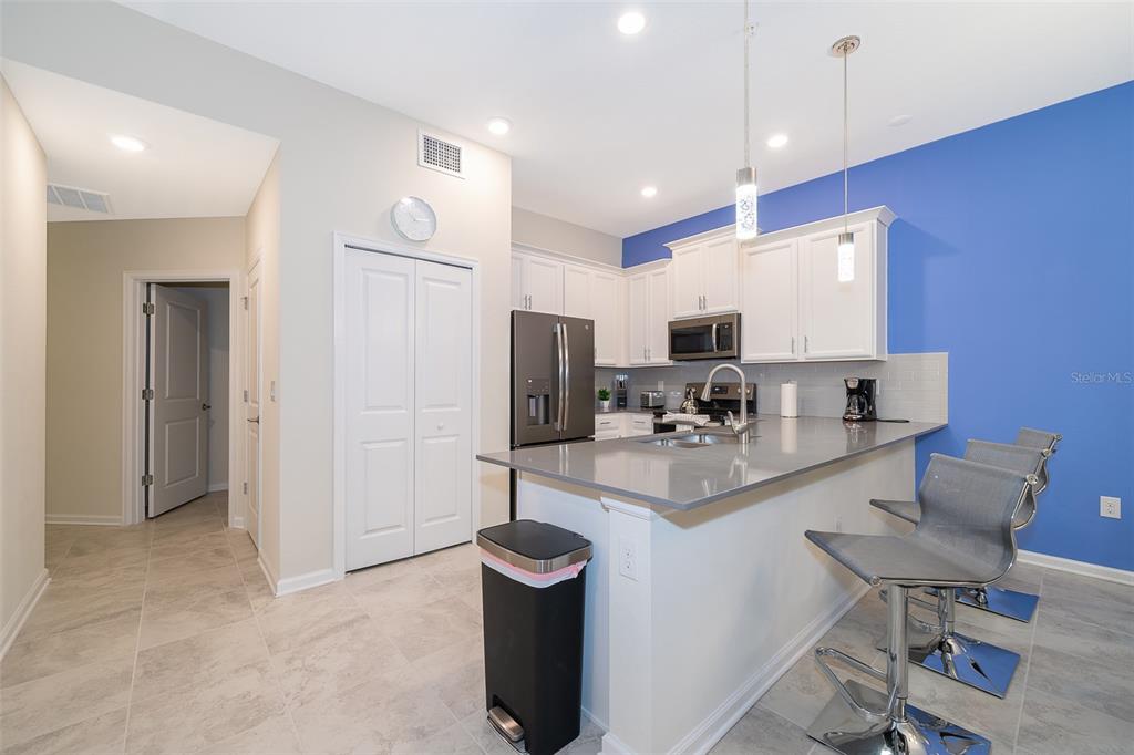 817 Ocean Course Avenue Davenport, FL 33896 - Photo 11 of 32 a kitchen with sink refrigerator and microwave