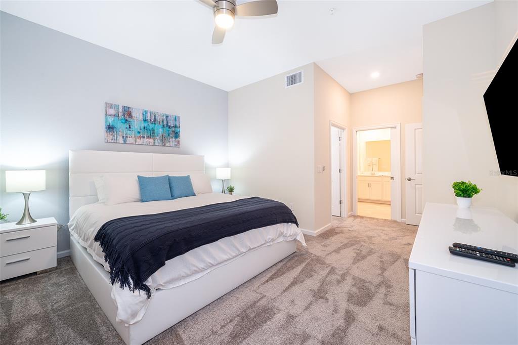 817 Ocean Course Avenue Davenport, FL 33896 - Photo 13 of 32 a bedroom with a large bed and a chandelier