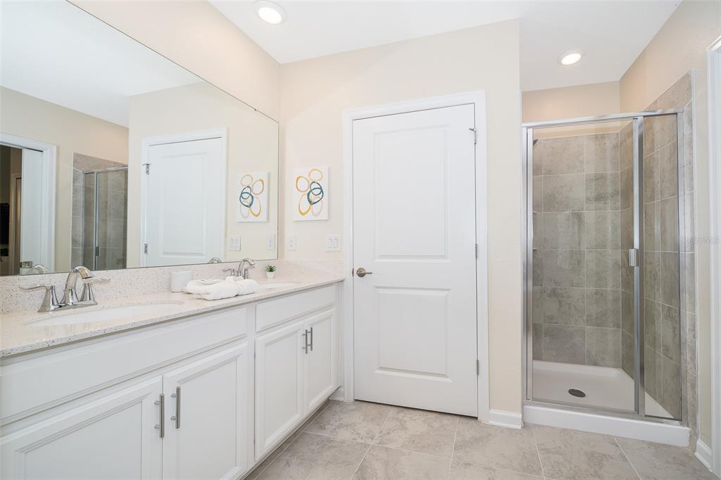 817 Ocean Course Avenue Davenport, FL 33896 - Photo 16 of 32 a bathroom with a shower sink and mirror
