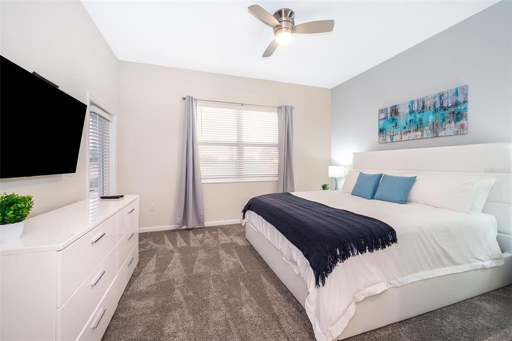 817 Ocean Course Avenue Davenport, FL 33896 - Photo 4 of 32 a bedroom with a bed and a flat screen tv