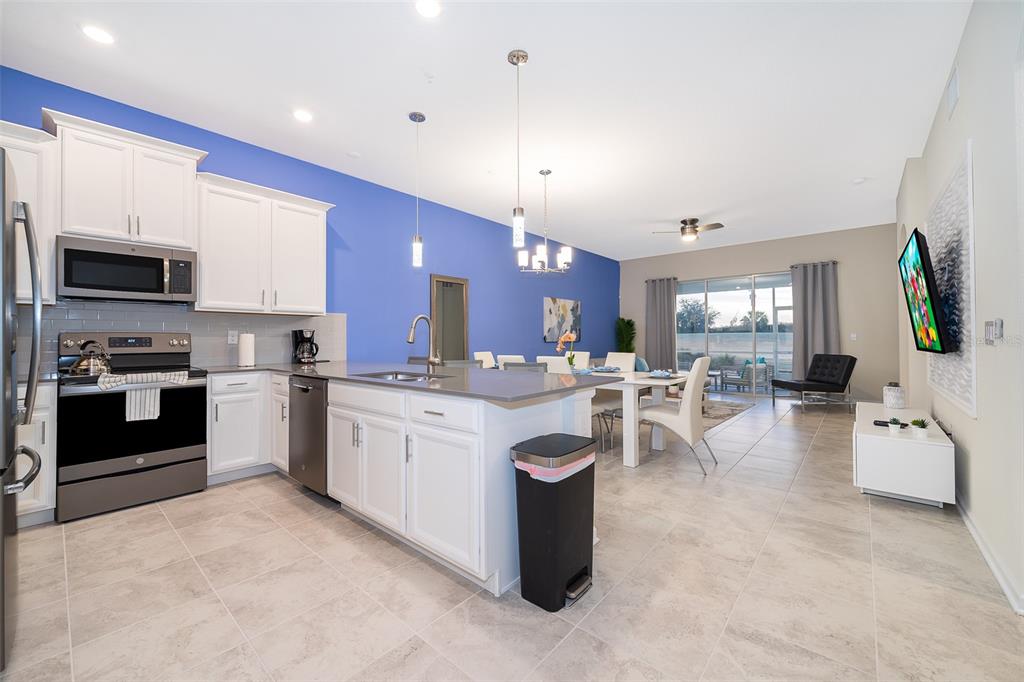 817 Ocean Course Avenue Davenport, FL 33896 - Photo 9 of 32 a large white kitchen with lots of counter space a sink appliances and cabinets