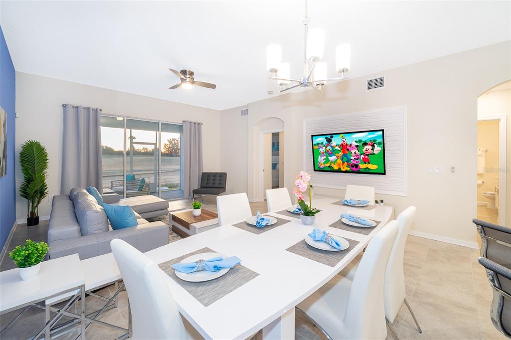 817 Ocean Course Avenue Davenport, FL 33896 - Photo 10 of 32 a dining room with furniture a large window and a chandelier