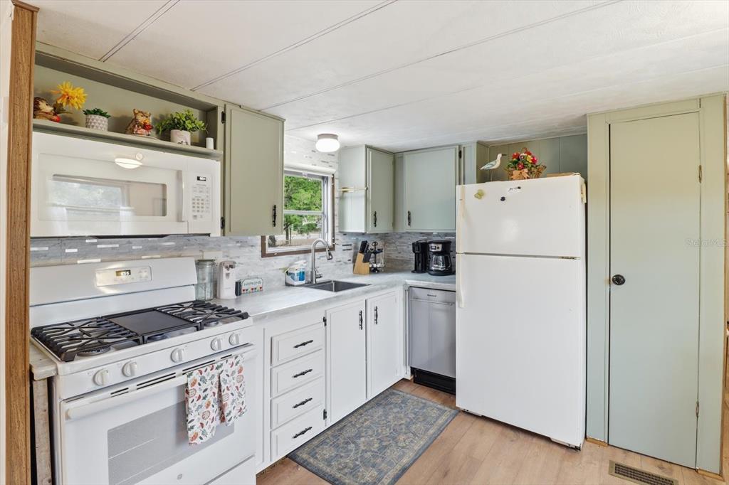 7749 West Chassahowitzka Street Homosassa, FL 34446 - Photo 12 of 30 a kitchen with a white cabinets and white appliances