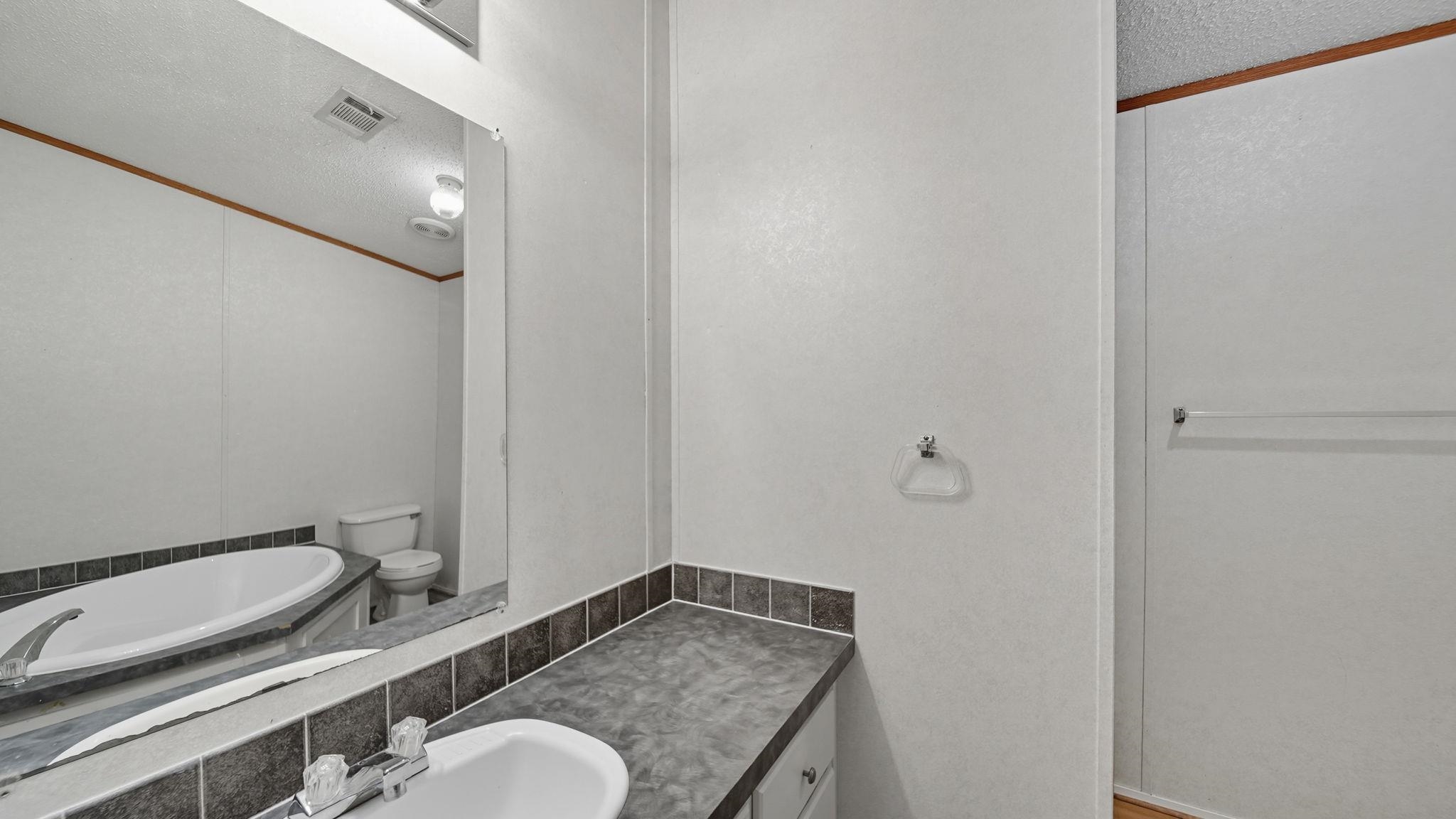 835 Robertson Road Mason, TN 38049 - Photo 6 of 22 a bathroom with a granite countertop sink mirror vanity and toilet